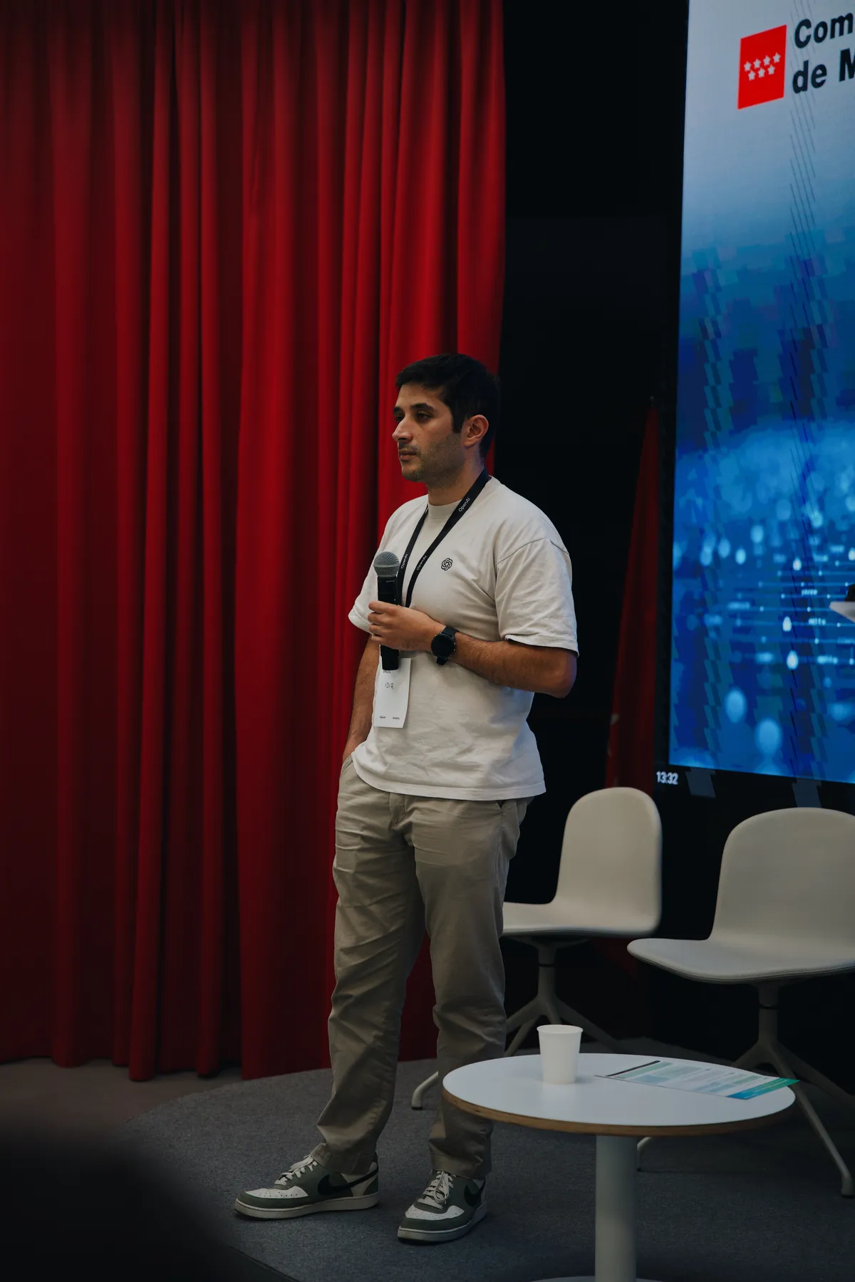 Idir Ouhab speaks with a microphone on stage at OpenAI Academy, in collaboration with Digitaliza Madrid.